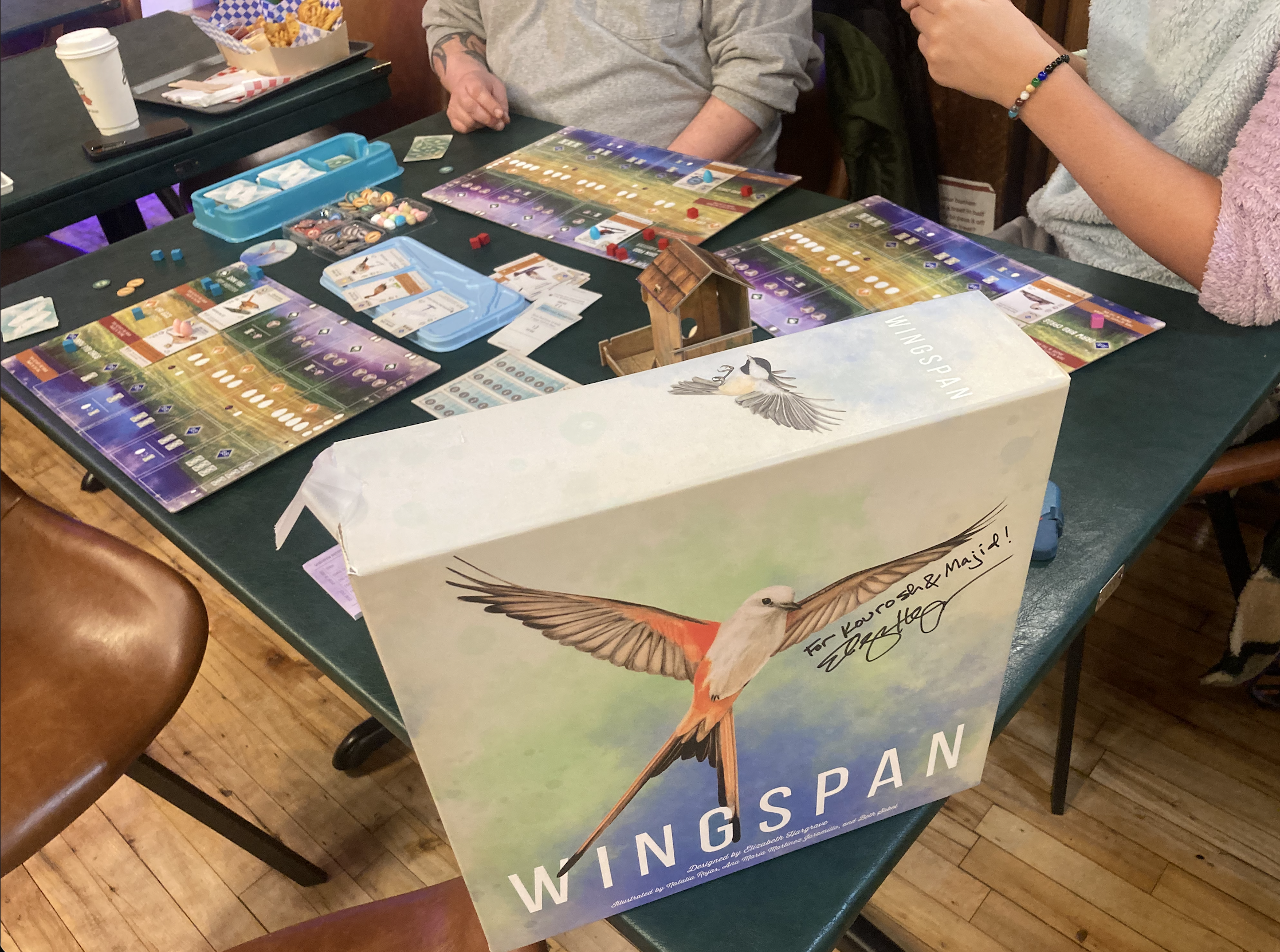 Players mid-game at Wingspan at a local café
